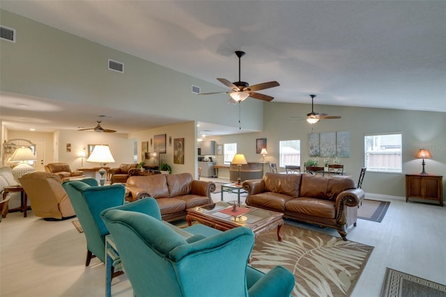 living area with light wood-type flooring, a wealth of natural light, and visible vents