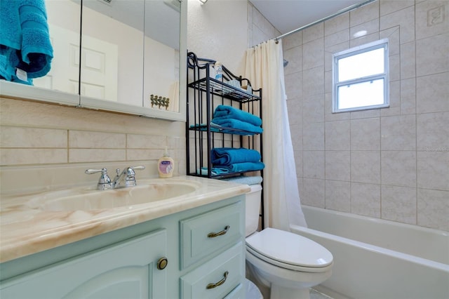 full bath featuring toilet, tasteful backsplash, shower / bath combo, and vanity