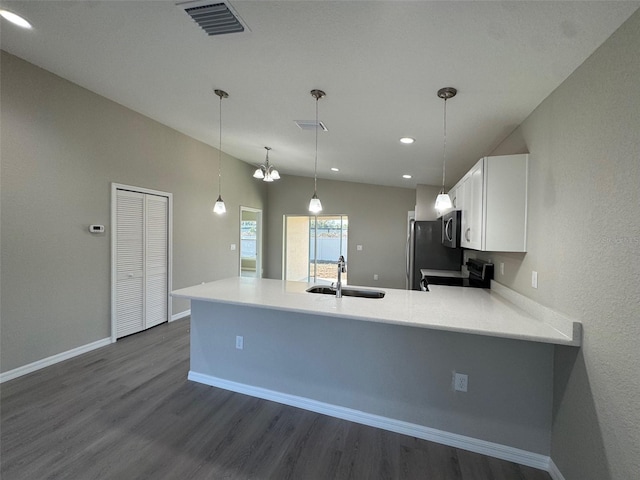 kitchen featuring range with electric cooktop, light countertops, visible vents, and a peninsula