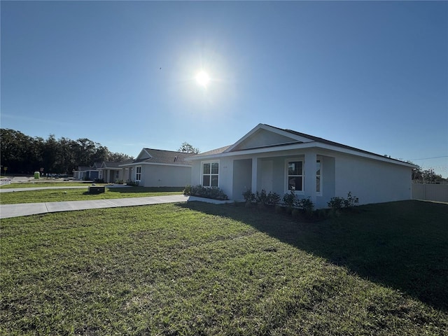 single story home featuring a front lawn and stucco siding