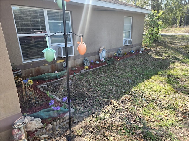 view of home's exterior with a yard, cooling unit, and stucco siding