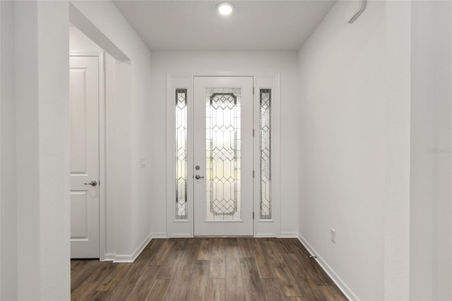 foyer featuring dark wood-style floors and baseboards