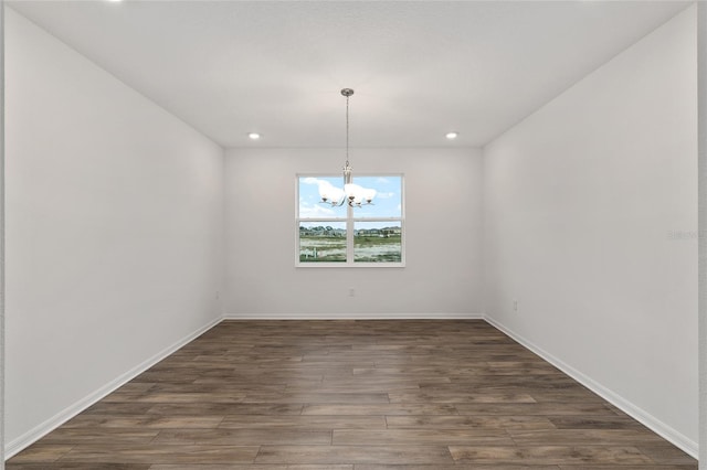 interior space featuring baseboards, dark wood-type flooring, recessed lighting, and an inviting chandelier