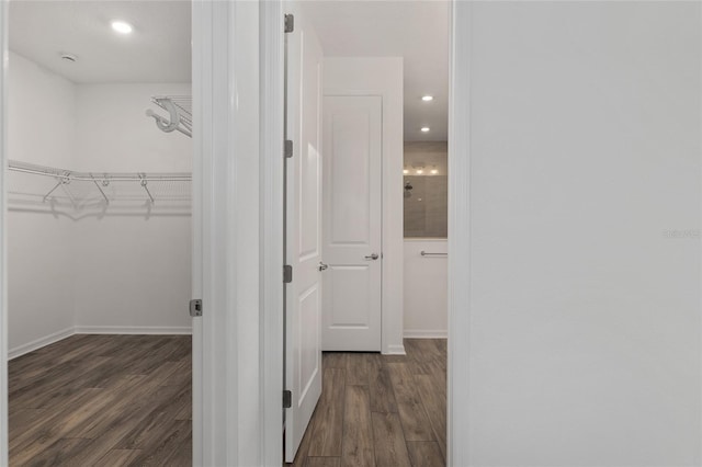 hallway with dark wood-type flooring, recessed lighting, and baseboards