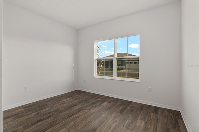 empty room with baseboards and dark wood-style flooring