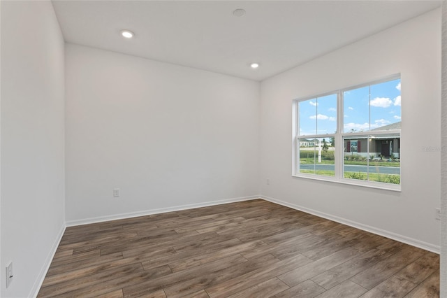 spare room with recessed lighting, wood finished floors, and baseboards