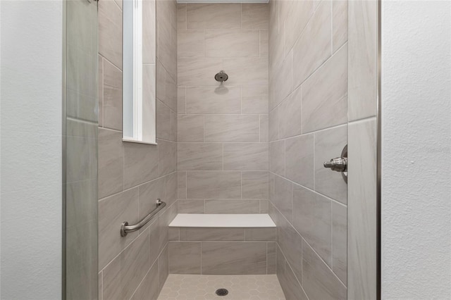 full bath featuring a textured wall and a shower stall