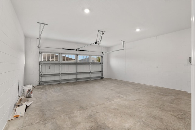 garage with a garage door opener and recessed lighting