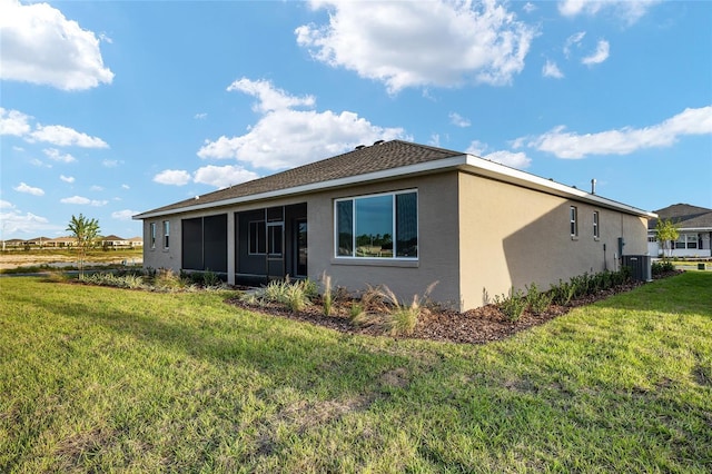 rear view of house with a yard, cooling unit, and stucco siding