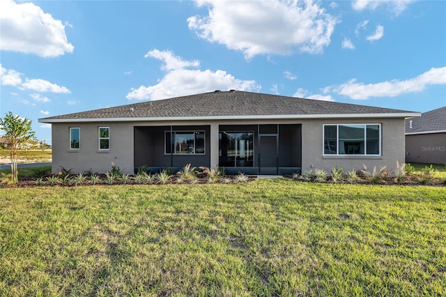 back of house featuring stucco siding and a yard