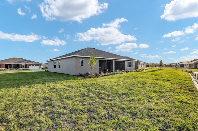 back of property featuring stucco siding, a residential view, and a yard