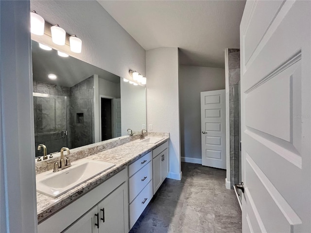 bathroom with a sink, a shower stall, baseboards, and double vanity