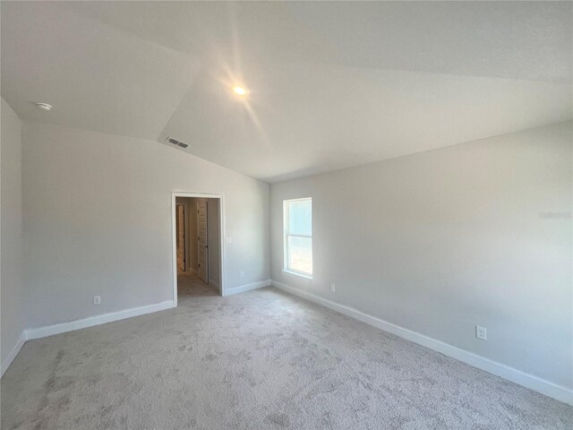 4381 SW 90th Pl, Ocala, FL 34476 - empty room featuring vaulted ceiling, light carpet, and a smoke detector