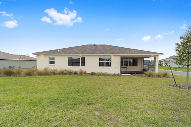 rear view of property featuring a lawn and stucco siding