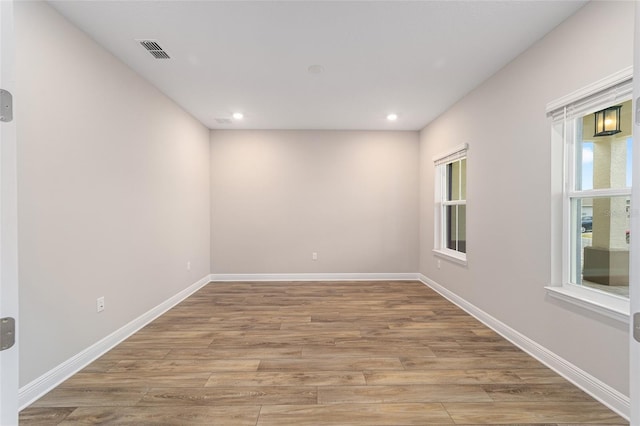 spare room featuring baseboards, visible vents, wood finished floors, and recessed lighting