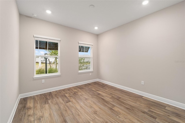 empty room featuring baseboards, wood finished floors, and recessed lighting