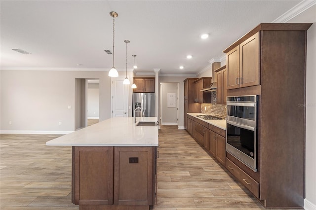 kitchen with stainless steel appliances, light wood-type flooring, crown molding, and a sink