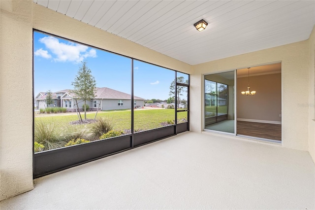 unfurnished sunroom featuring a residential view and a notable chandelier