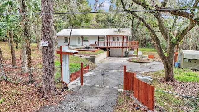 view of front facade featuring a gate, driveway, and fence