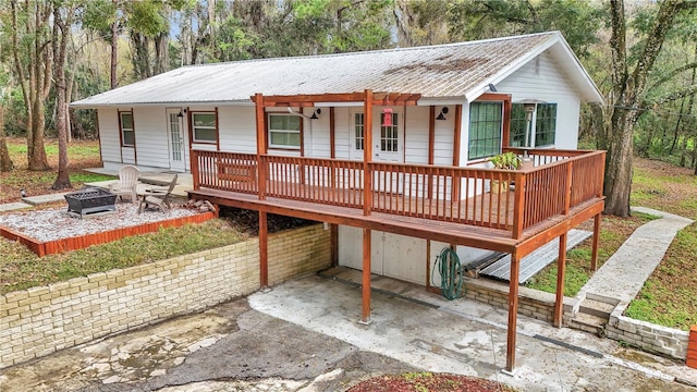 single story home with a carport, metal roof, and an outdoor fire pit