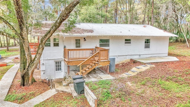 rear view of house featuring a deck and stairway