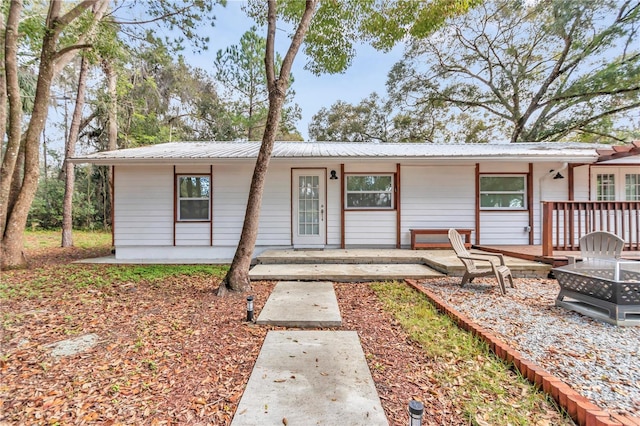 single story home with metal roof and a fire pit