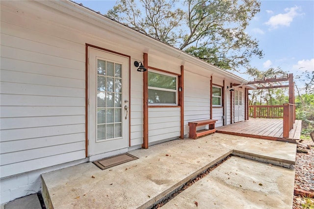 doorway to property featuring a patio, a wooden deck, and a pergola