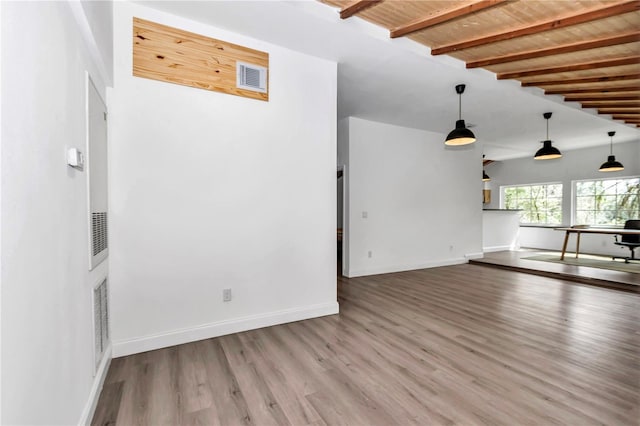 interior space featuring visible vents, lofted ceiling with beams, baseboards, and wood finished floors