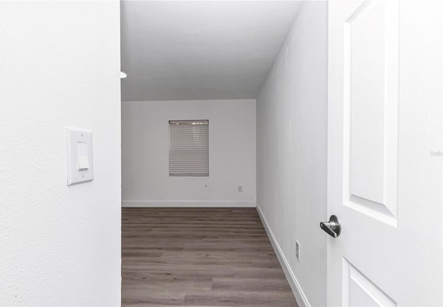 unfurnished room featuring dark wood-style floors and baseboards