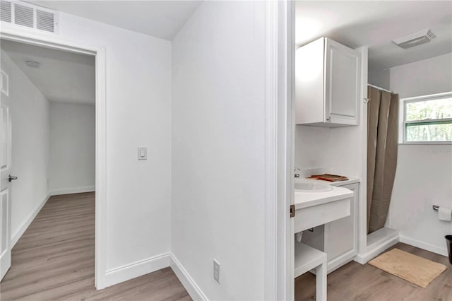 interior space with wood finished floors, visible vents, and baseboards