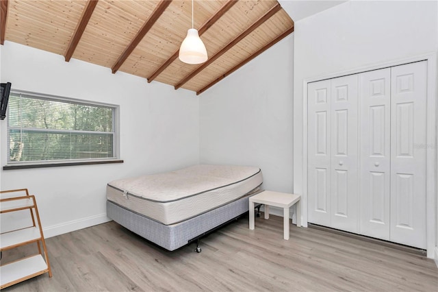 bedroom with vaulted ceiling with beams, wooden ceiling, baseboards, a closet, and light wood finished floors