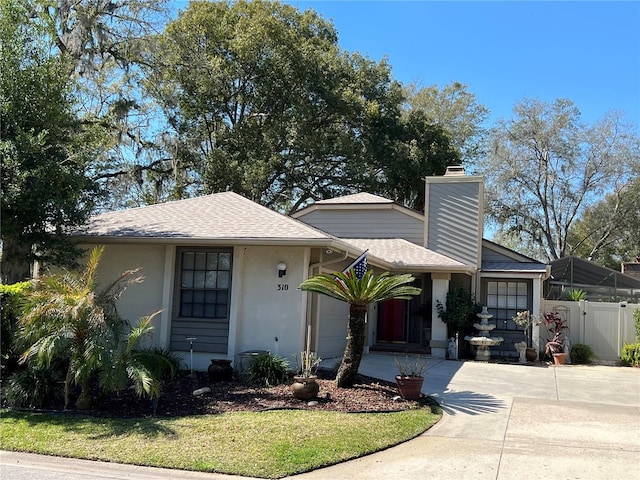 view of front of house with a chimney, stucco siding, a shingled roof, a garage, and driveway