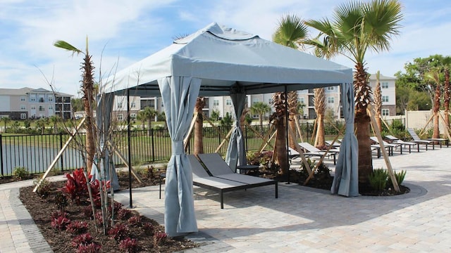 view of jungle gym featuring a water view, fence, and a gazebo