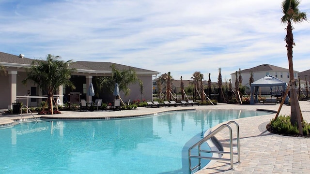 pool with a patio area and a gazebo