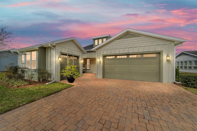 view of front of home featuring a garage, decorative driveway, and board and batten siding