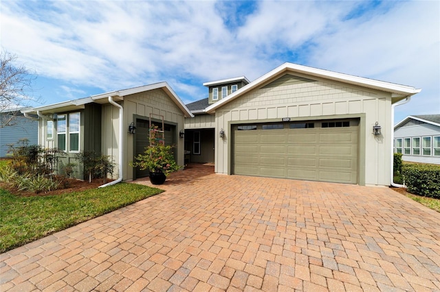 ranch-style home featuring board and batten siding, decorative driveway, and an attached garage