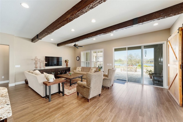 living area with beamed ceiling, light wood-type flooring, a ceiling fan, and baseboards