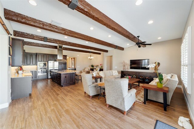 living room featuring recessed lighting, a ceiling fan, light wood-type flooring, beamed ceiling, and baseboards