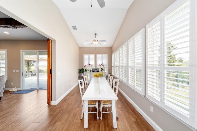 dining space with a ceiling fan, lofted ceiling, baseboards, and wood finished floors