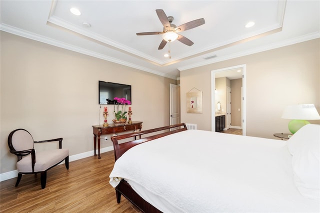 bedroom with light wood finished floors, baseboards, and a raised ceiling