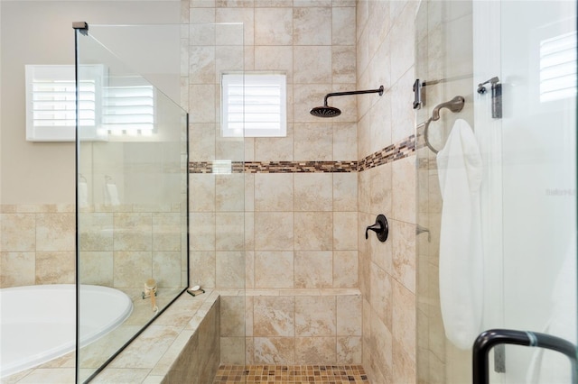 bathroom featuring plenty of natural light, a shower stall, and a garden tub