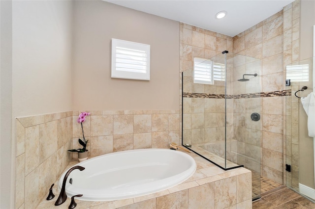 bathroom featuring a stall shower and a bath