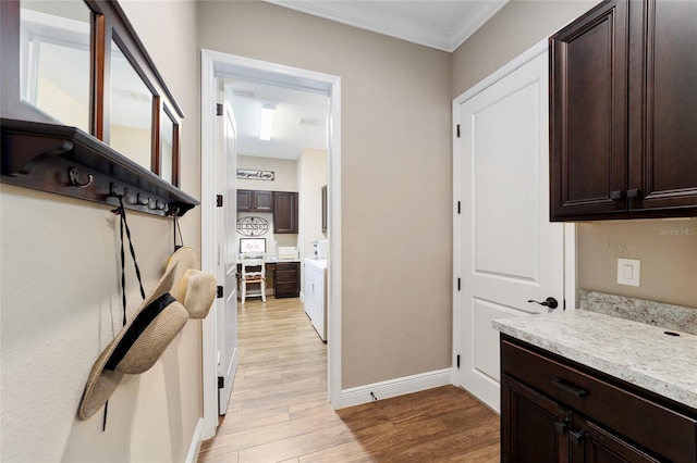 interior space with light stone counters, light wood-style floors, ornamental molding, dark brown cabinets, and baseboards