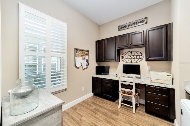 office space with light wood-type flooring, built in study area, and baseboards