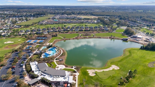 drone / aerial view with view of golf course and a water view