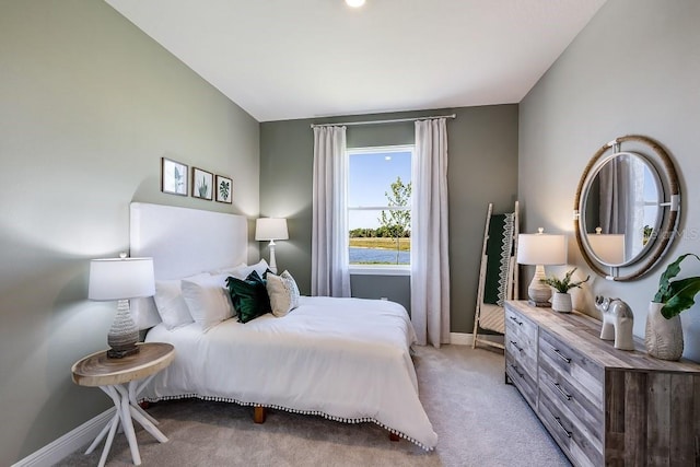 bedroom with light colored carpet and baseboards