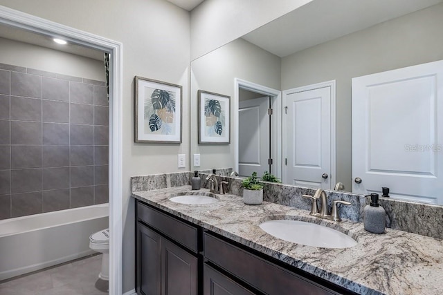 bathroom with tile patterned floors, a sink, toilet, and double vanity