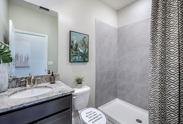 full bath featuring toilet, visible vents, a tile shower, and vanity