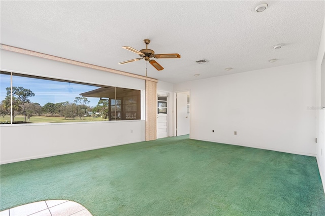 spare room with a textured ceiling, carpet floors, and visible vents