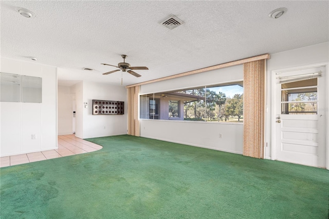 spare room with a ceiling fan, a textured ceiling, visible vents, and carpet flooring